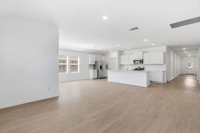 a view of a kitchen with a sink and dishwasher a refrigerator with wooden floor
