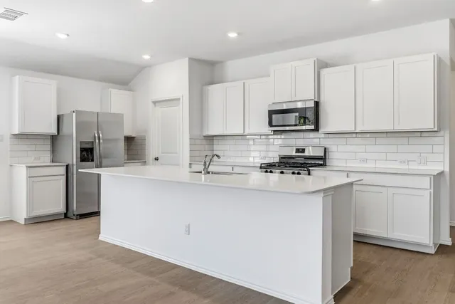 a kitchen with stainless steel appliances a refrigerator sink and microwave