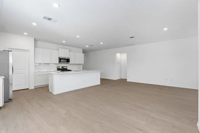 a view of kitchen with kitchen island white cabinets and refrigerator
