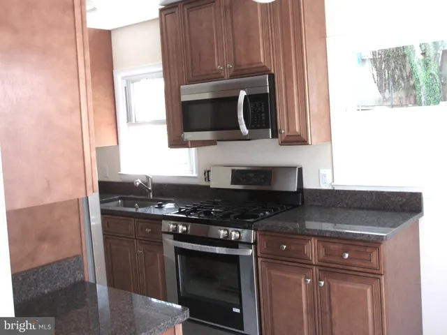 a kitchen with stainless steel appliances granite countertop a stove and a microwave