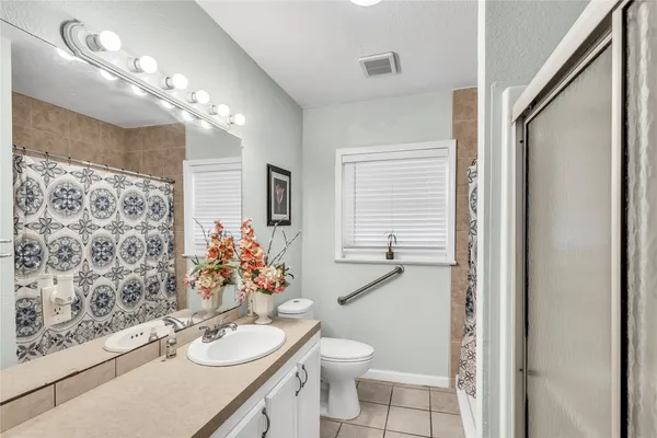 a bathroom with a double vanity sink toilet and a mirror