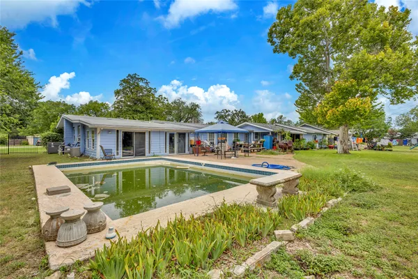 a view of house with swimming pool outdoor seating