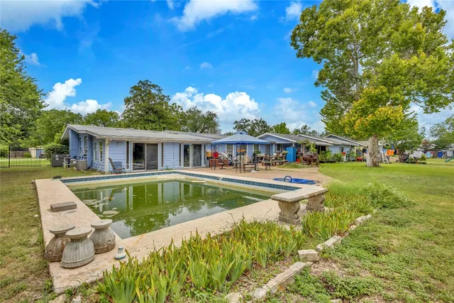 a view of house with swimming pool outdoor seating