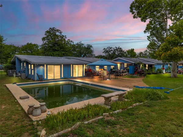 a view of house with swimming pool and outdoor seating