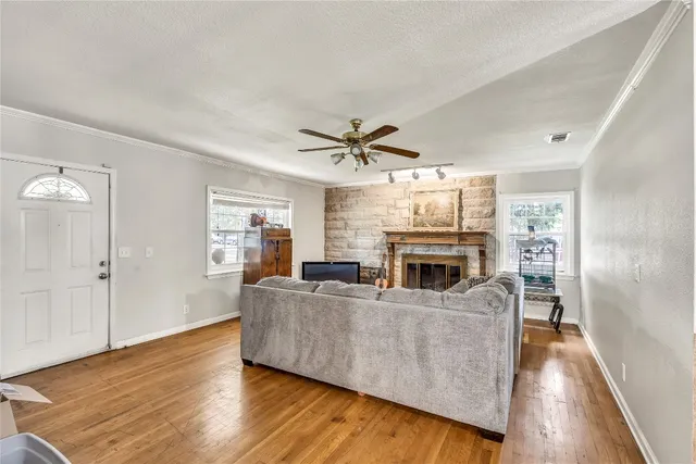 a living room with fireplace furniture and a wooden floor