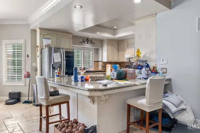 a kitchen with stainless steel appliances granite countertop a stove a sink and a white refrigerator
