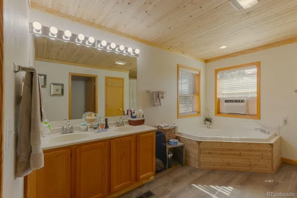 a bathroom with a tub sink and mirror