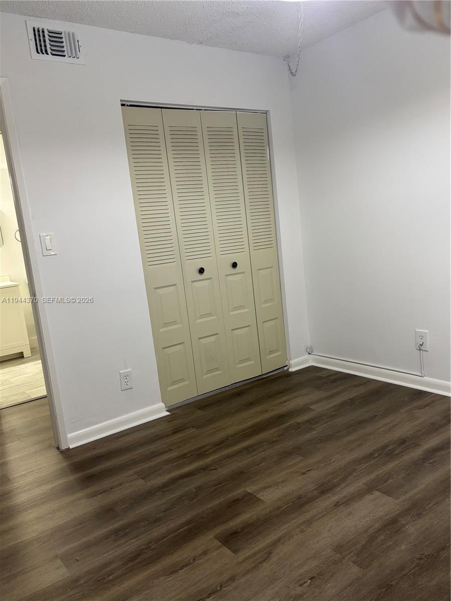10023 Winding Lake Road, Unit 101 Sunrise, FL 33351 - Photo 12 of 19 a view of an empty room with wooden floor and a window