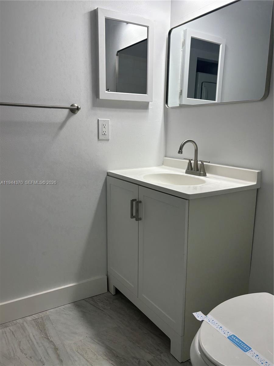 10023 Winding Lake Road, Unit 101 Sunrise, FL 33351 - Photo 15 of 19 a bathroom with a sink a toilet and mirror