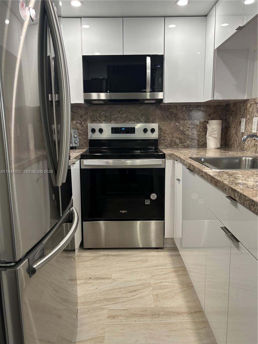 10023 Winding Lake Road, Unit 101 Sunrise, FL 33351 - Photo 2 of 19 a kitchen with a stove and a refrigerator