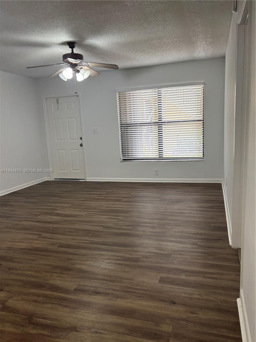 10023 Winding Lake Road, Unit 101 Sunrise, FL 33351 - Photo 7 of 19 a view of an empty room with wooden floor and a window