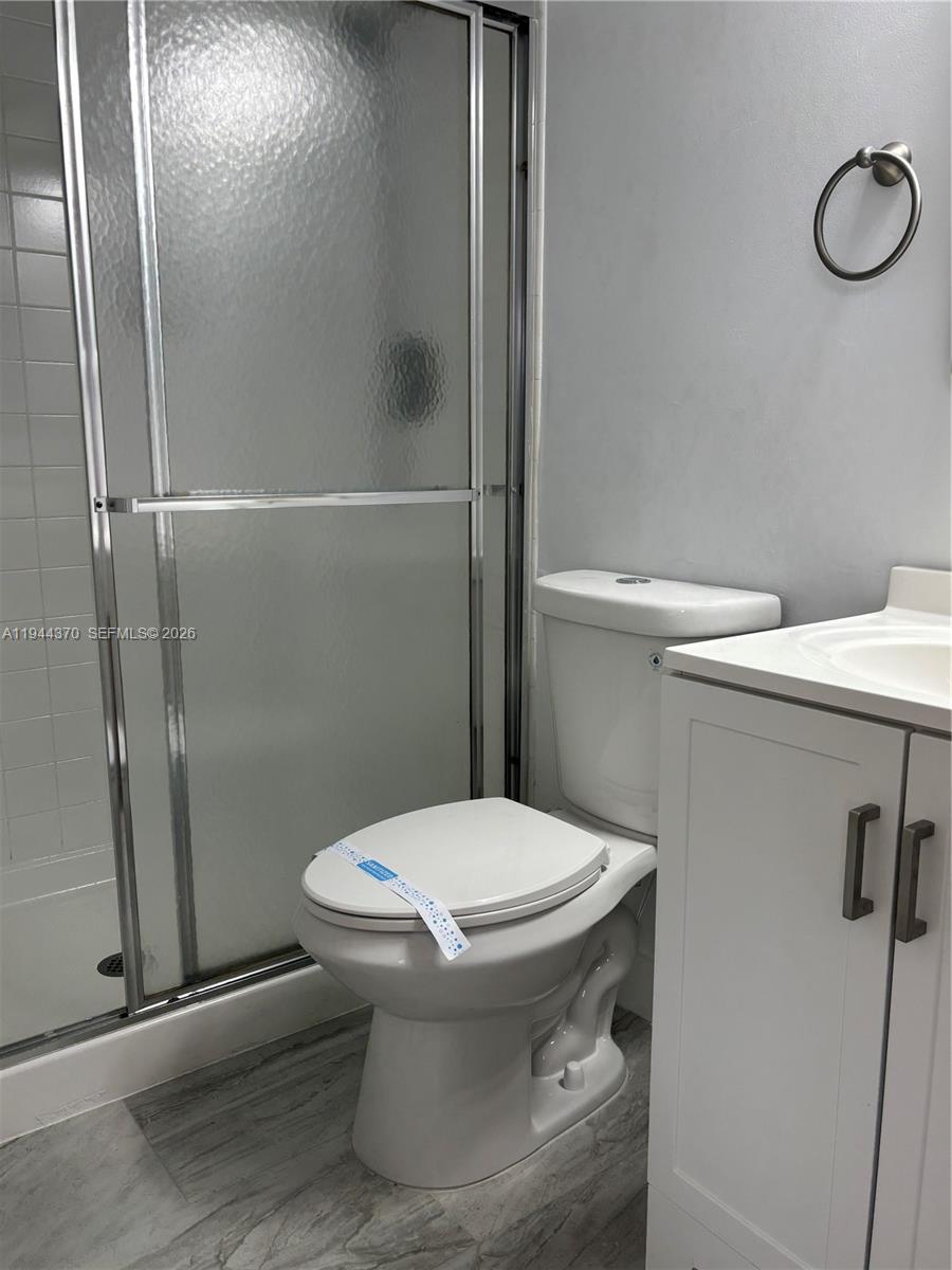 10023 Winding Lake Road, Unit 101 Sunrise, FL 33351 - Photo 10 of 19 a bathroom with a toilet and a shower