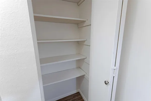 a view of walk in closet with empty racks