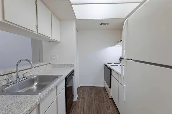 a kitchen with sink a stove and cabinets