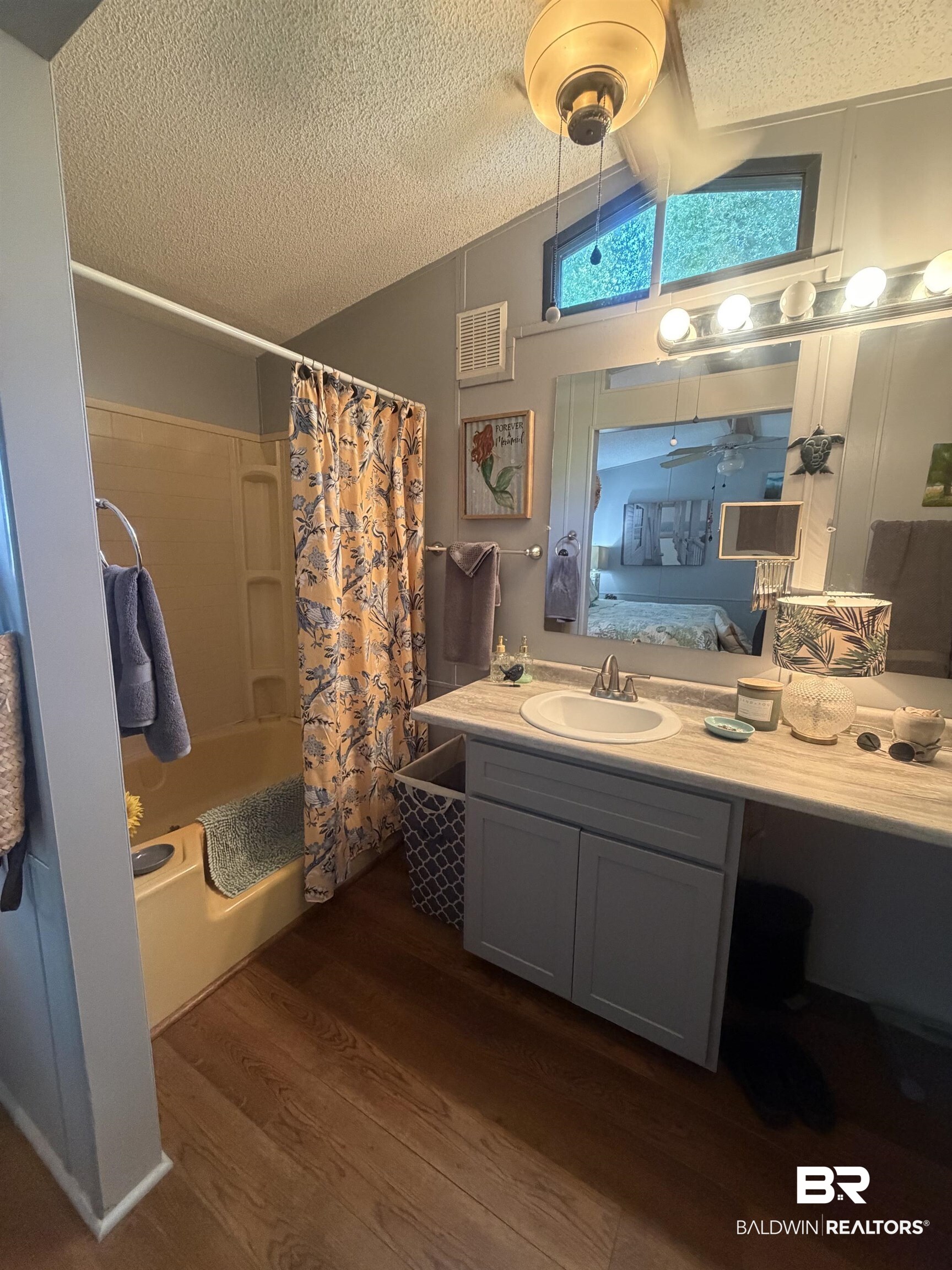 1620 Del Rey Drive Lillian, AL 36549 - Photo 16 of 45 Bathroom featuring wood-finish flooring, a single vanity with a light-toned countertop, and a built-in tub with shower
