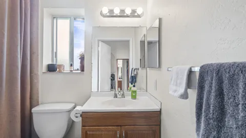 a bathroom with a sink vanity mirror and toilet