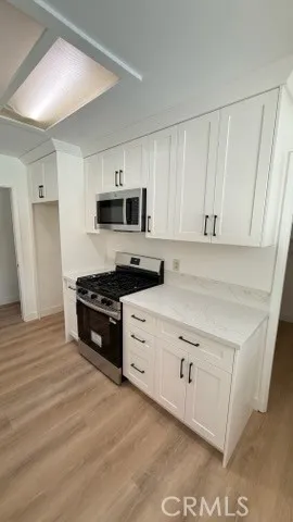a kitchen with granite countertop white cabinets and black appliances