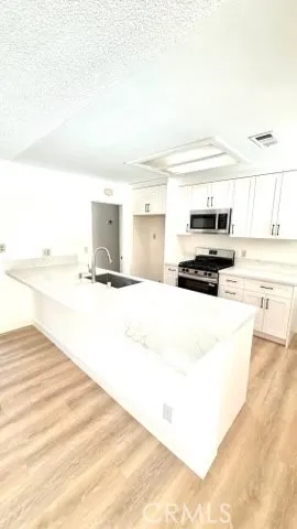 a large white kitchen with kitchen island sink refrigerator and stove