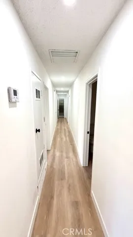 a view of a hallway with wooden floor