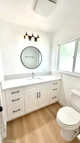 a bathroom with a granite countertop toilet sink and mirror