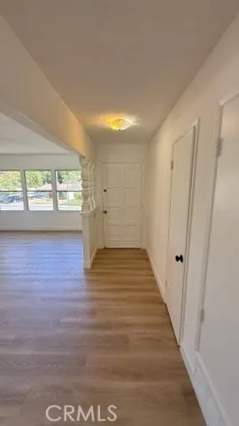 a view of empty room with wooden floor and fan