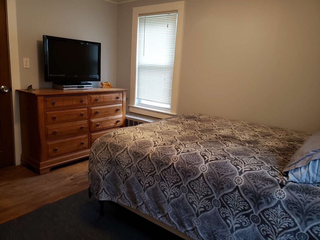 32 Birch Road Natick, MA 01760 - Photo 20 of 38 a bedroom with a bed and a flat screen tv