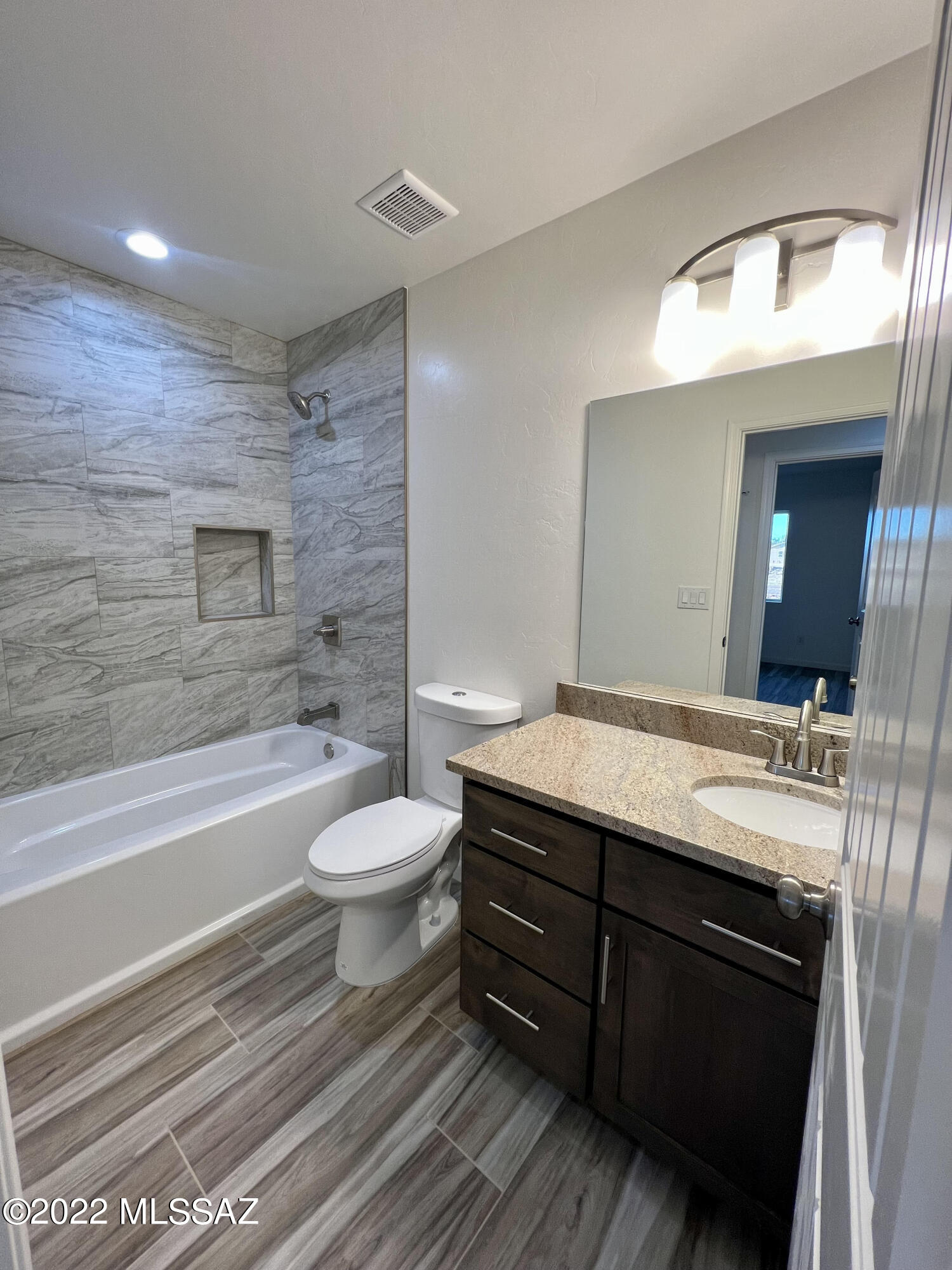 1696 Camino Barrera Rio Rico, AZ 85648 - Photo 22 of 30 a bathroom with a granite countertop toilet a sink and bathtub
