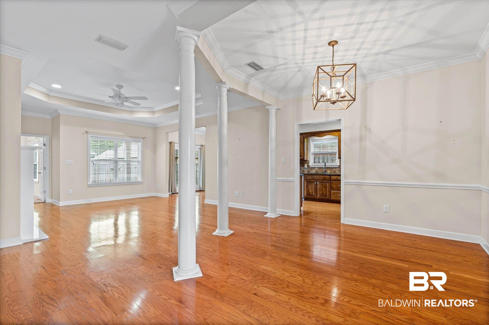 1003 Weatherby Street South Saraland, AL 36571 - Photo 5 of 31 Foyer featuring ornamental molding, ornate columns, light wood-style floors, hanging lights, and a raised ceiling