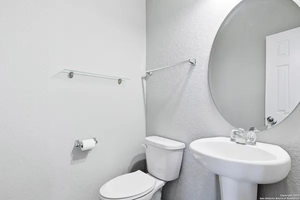 a bathroom with a sink toilet and a mirror
