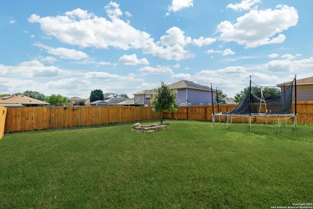 a view of a house with backyard and sitting area