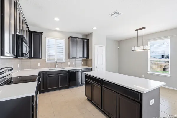 a kitchen with a sink dishwasher a stove and a refrigerator with wooden cabinets
