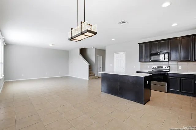 a kitchen with stainless steel appliances granite countertop a refrigerator a stove top oven a sink and dishwasher