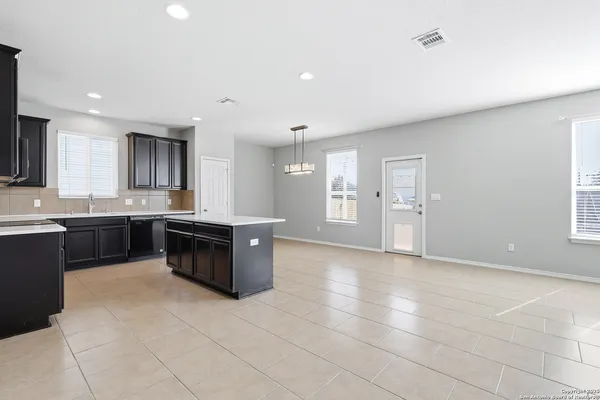 a large kitchen with a stove a sink a microwave and a counter top space