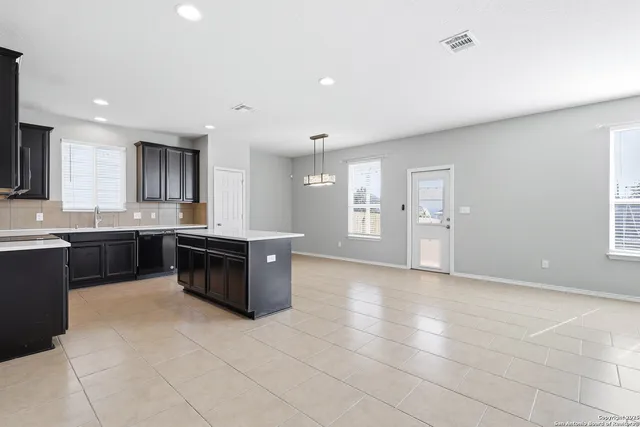a large kitchen with a stove a sink a microwave and a counter top space