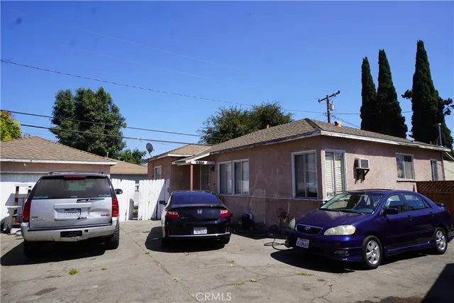 a front view of a house with cars parked