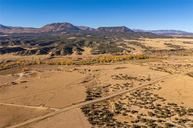 a view of a field with trees in background