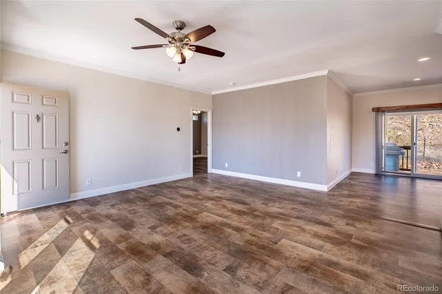 a view of a livingroom with a ceiling fan & hardwood floor