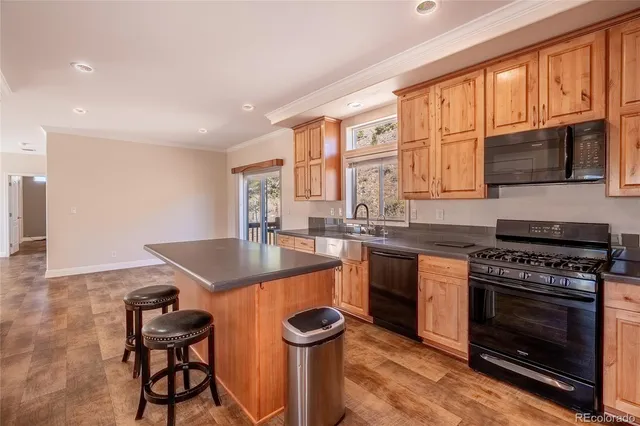 a kitchen with stainless steel appliances granite countertop a stove a sink and a microwave