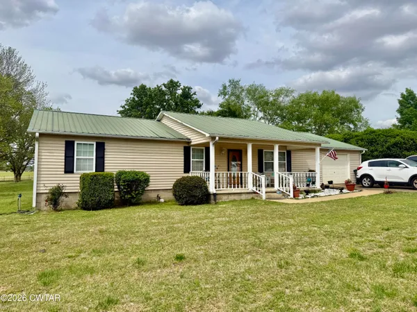 a view of a house with a yard and sitting area
