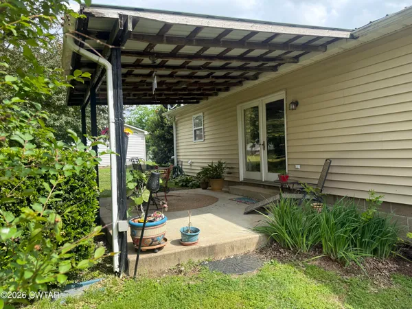 a view of backyard with plants and patio