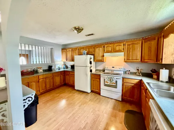 a kitchen with stainless steel appliances granite countertop a stove a sink dishwasher and a refrigerator