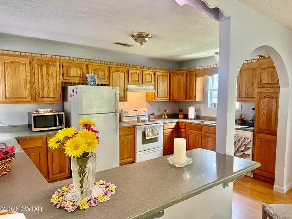 a kitchen with stainless steel appliances granite countertop a sink refrigerator and microwave