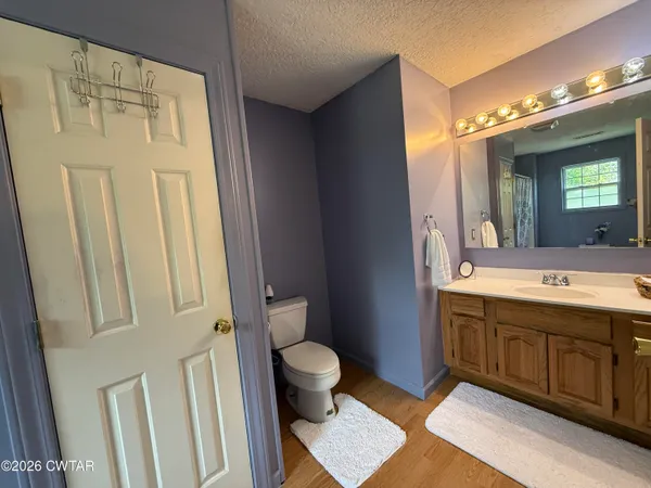 a spacious bathroom with a double vanity sink a toilet and a mirror