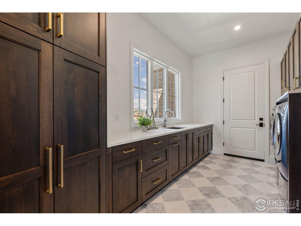 2568 Southwind Road Berthoud, CO 80513 - Photo 26 of 40 a bathroom with a double vanity sink a large mirror and a bathtub
