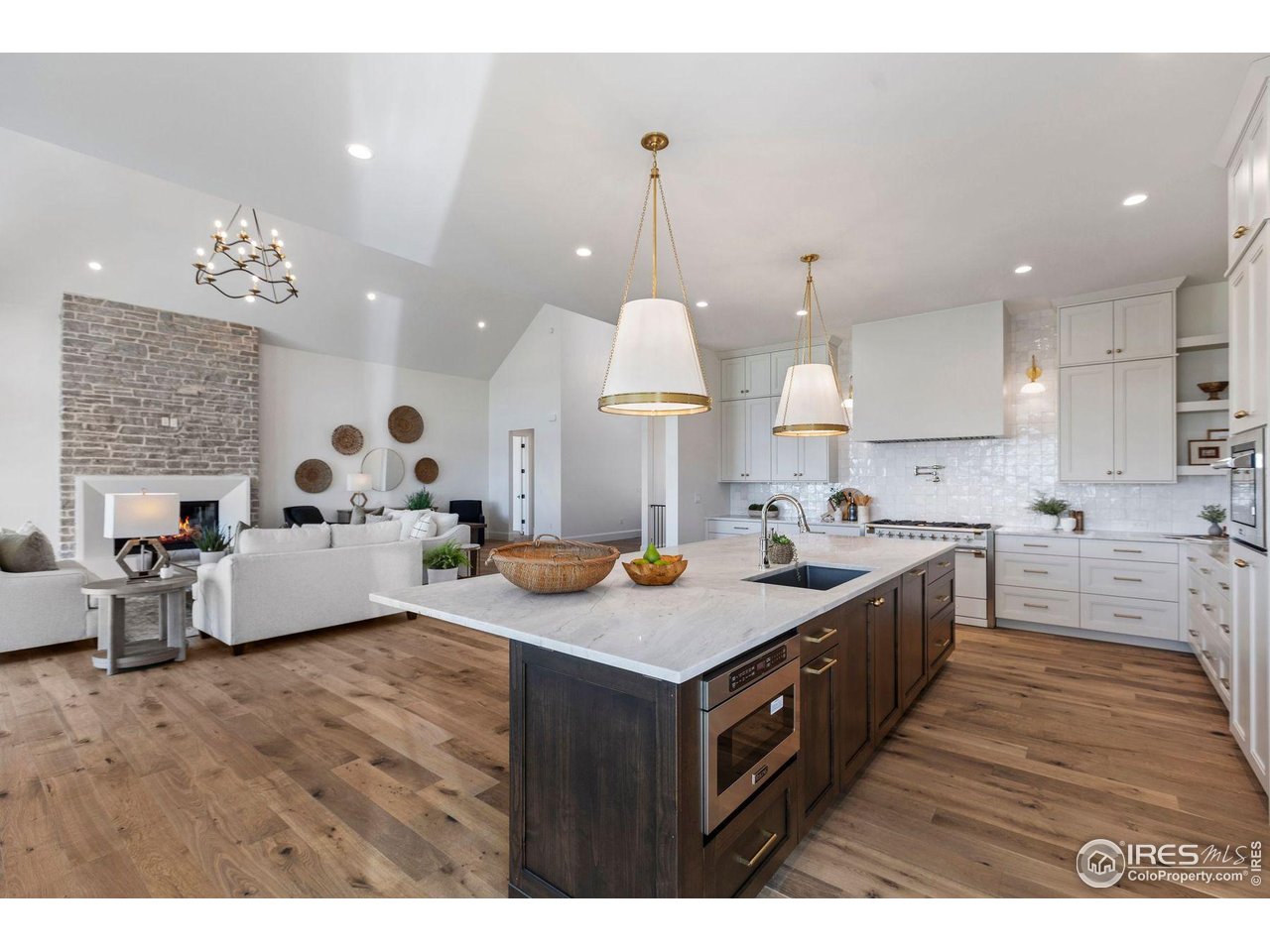 2568 Southwind Road Berthoud, CO 80513 - Photo 7 of 40 a kitchen with kitchen island a sink stove and wooden floor