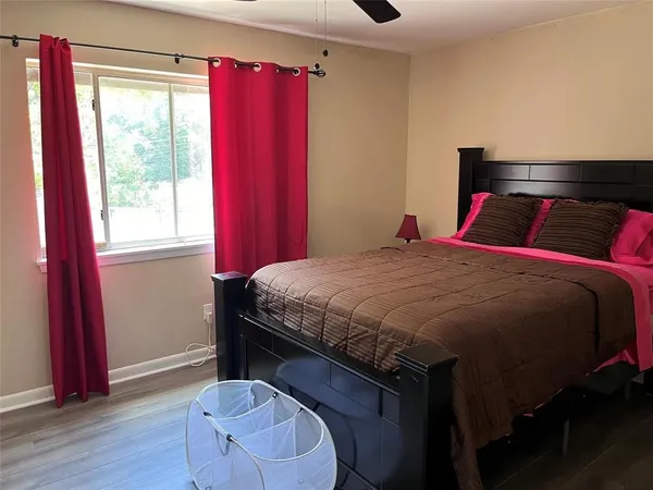 a bedroom with a bed and a flat tv screen on a dresser