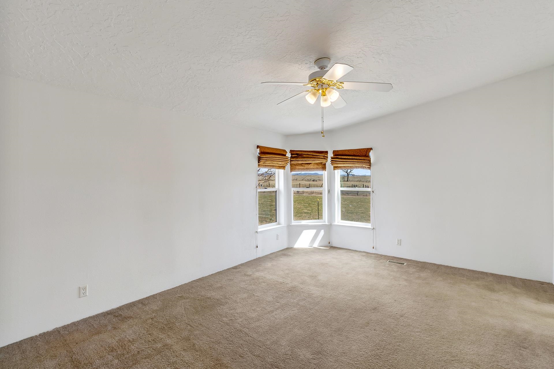 1940 10 Road Mack, CO 81525 - Photo 13 of 42 an empty room with a window and a ceiling fan