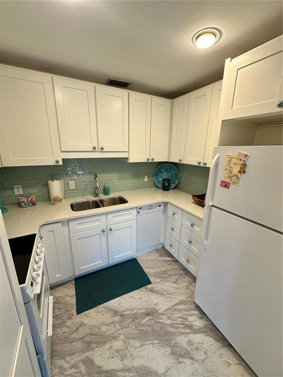 4578 Red Maple, Unit 904 Bradenton, FL 34210 - Photo 21 of 37 a kitchen with granite countertop white cabinets and white appliances
