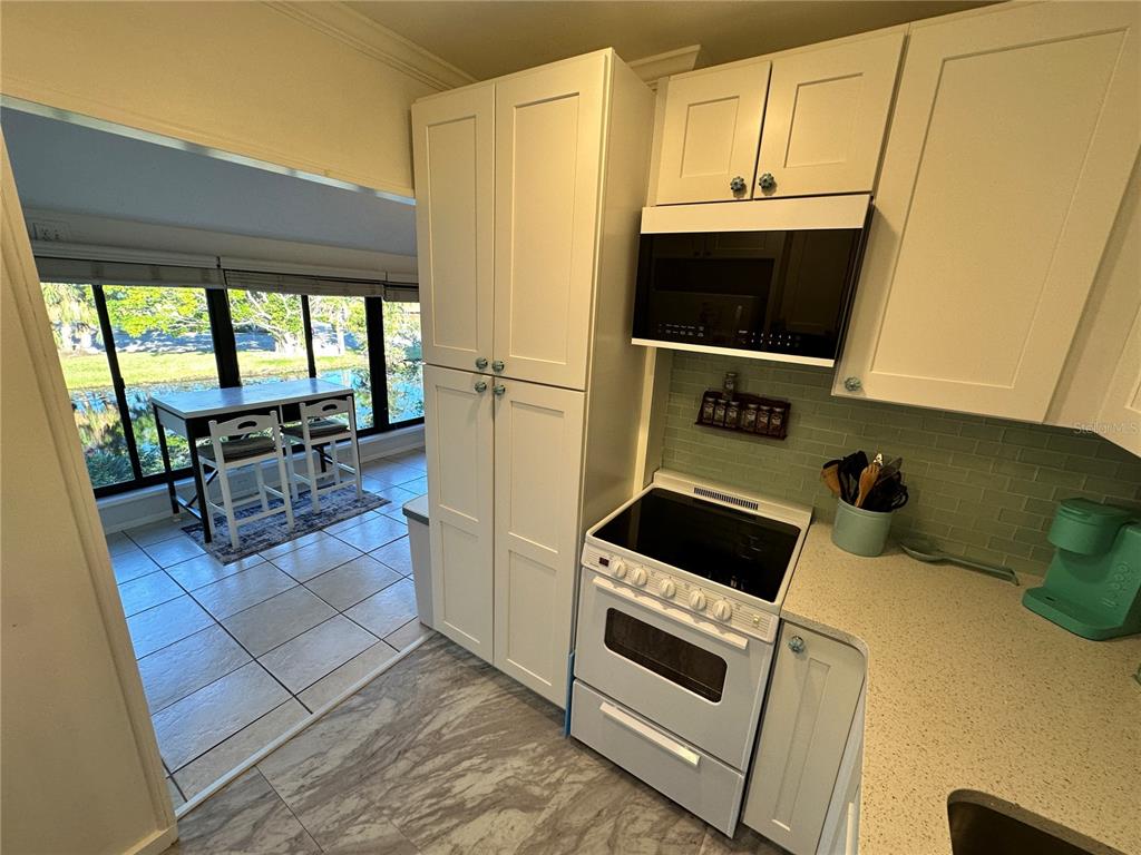 4578 Red Maple, Unit 904 Bradenton, FL 34210 - Photo 23 of 37 a kitchen with a stove and a microwave