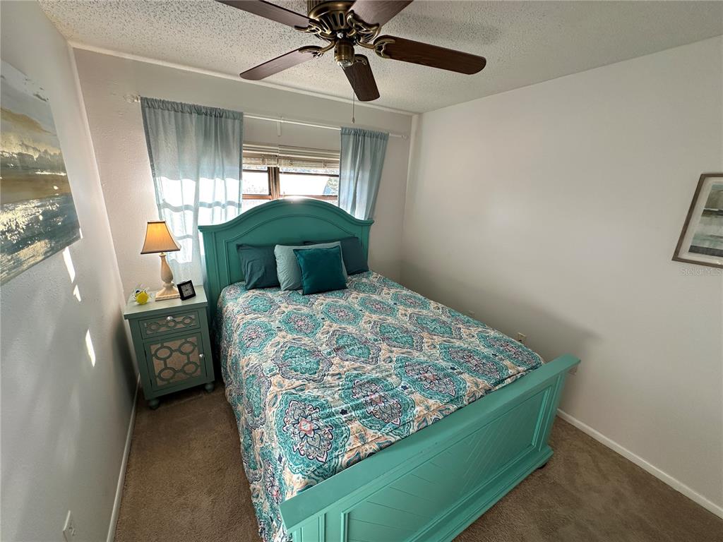 4578 Red Maple, Unit 904 Bradenton, FL 34210 - Photo 24 of 37 a bedroom with a bed and a chandelier